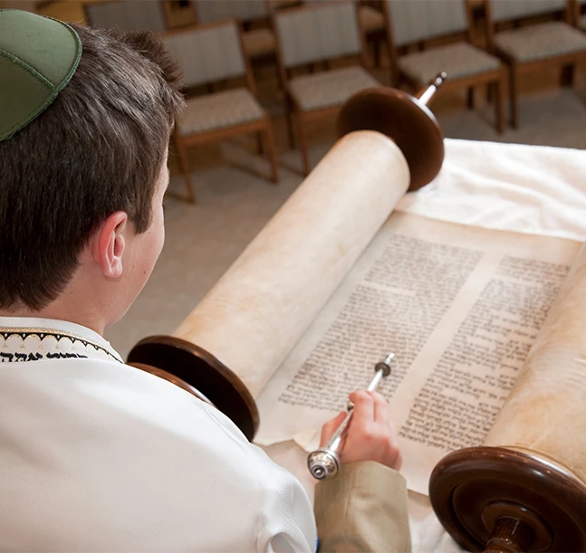 a boy reading a torah