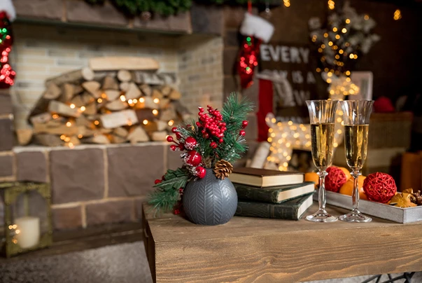 A cozy lounge area with a fireplace, wooden table, and champagne glasses.
