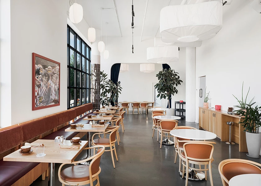 a dining area with tables, chairs, booths, and plants