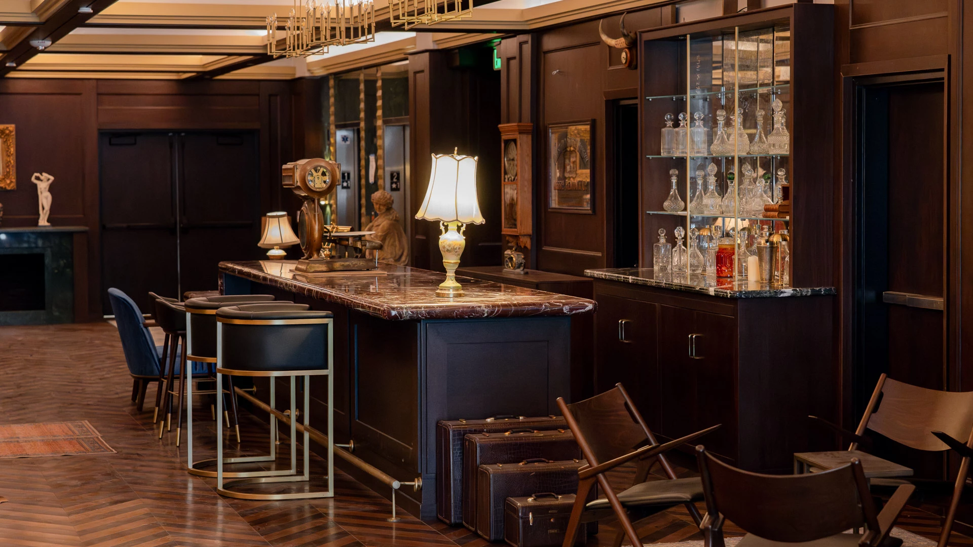A luxurious bar with a marble countertop, stools, and chairs.