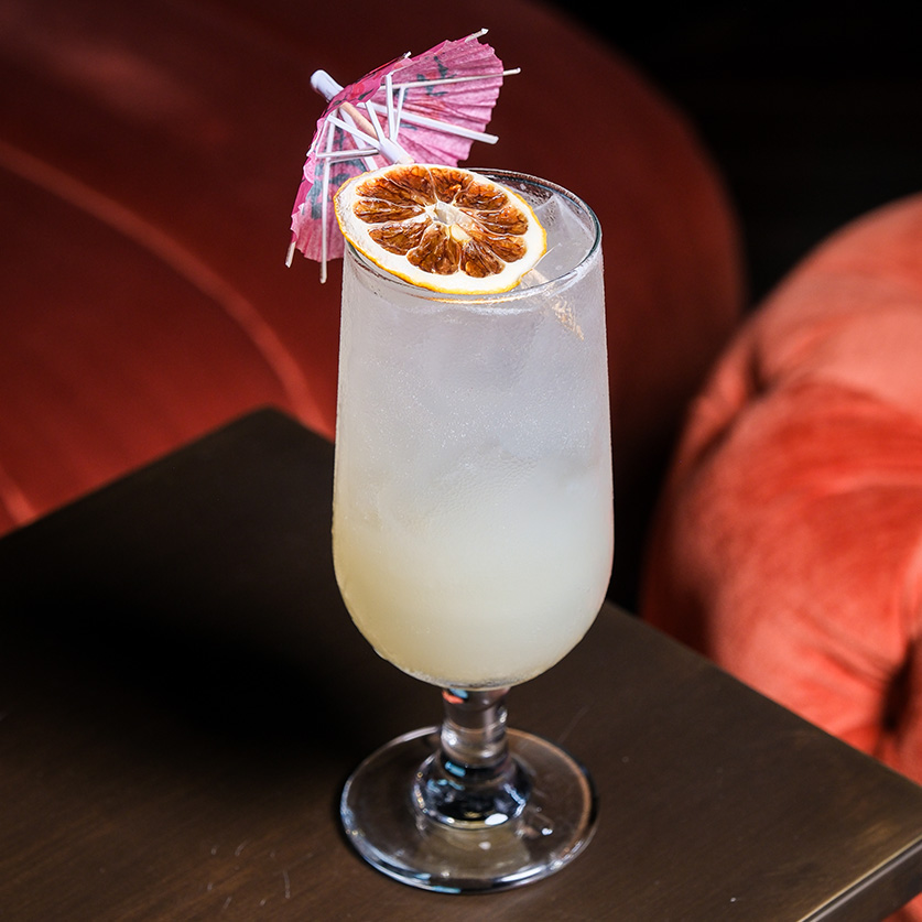 a glass with a drink and an umbrella on it