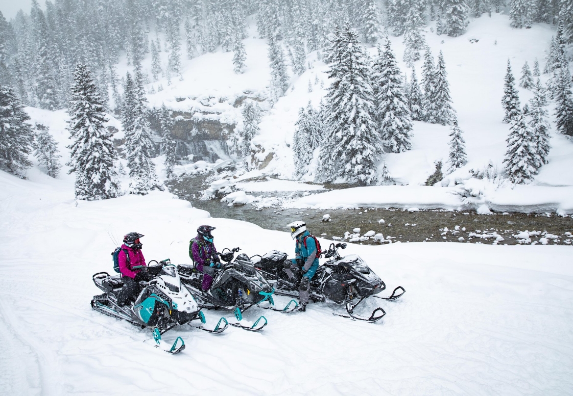 a group of people on snowmobiles in the snow