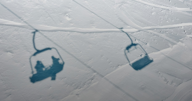 shadows of ski lift chairs on snow