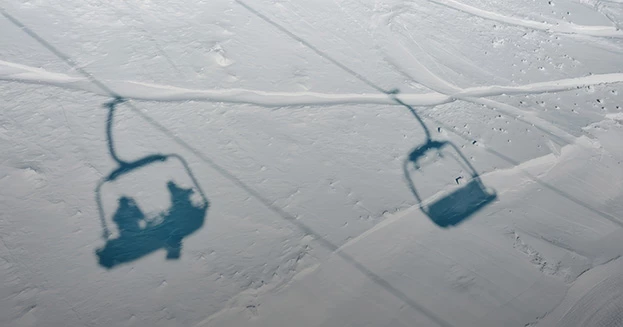 shadows of ski lift chairs on snow