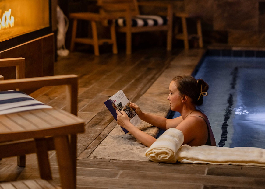 a woman reading a book in a pool