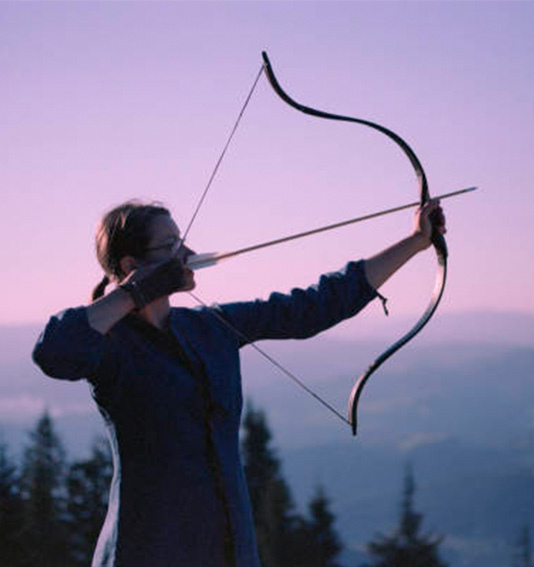 a woman shooting a bow and arrow