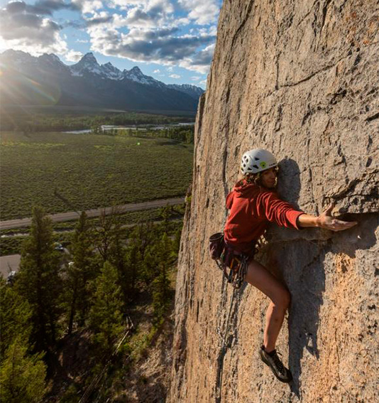 a woman climbing a rock wall