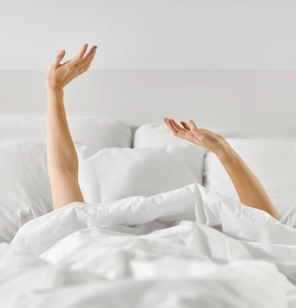 a person's hands in a bed