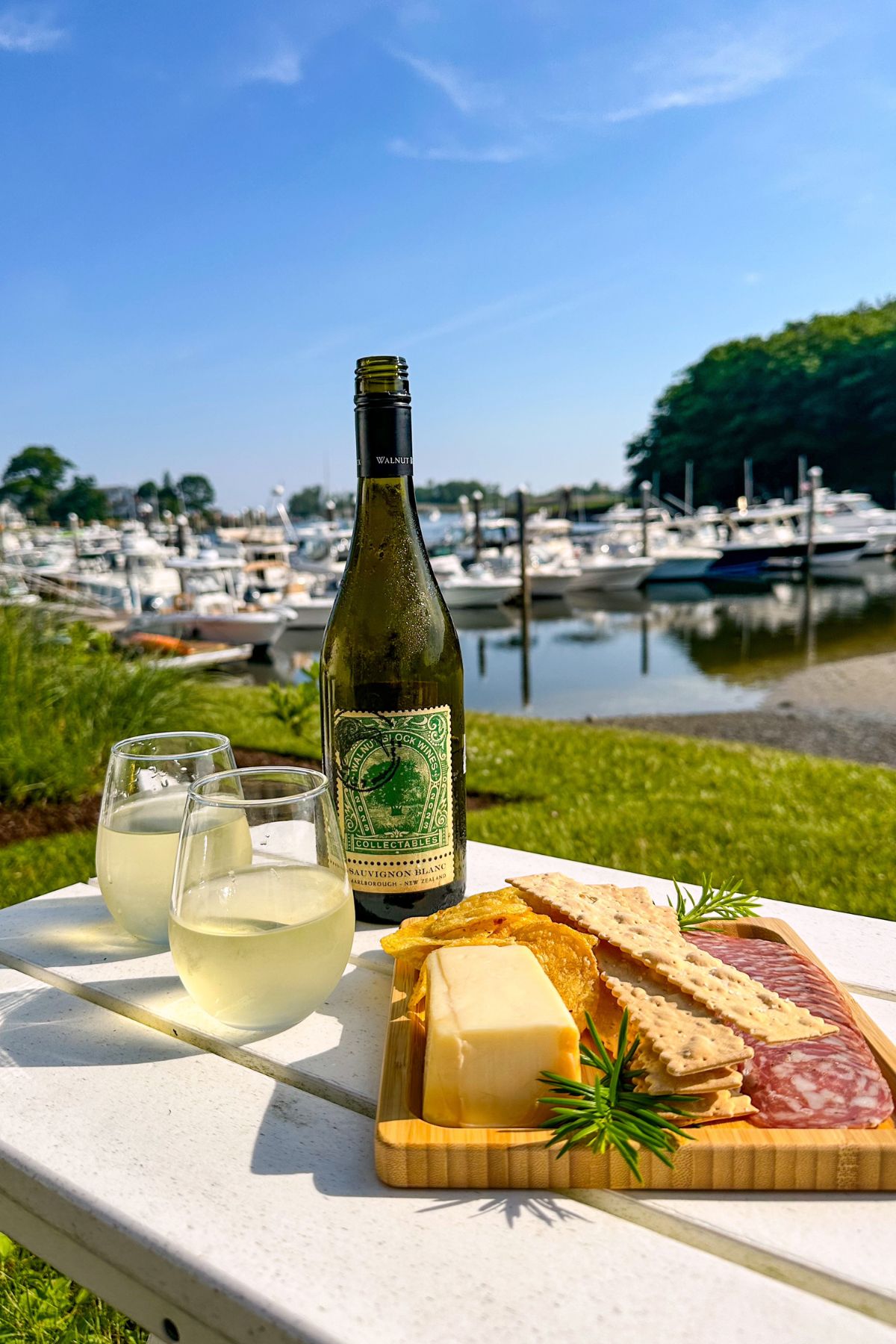 a bottle of wine and a platter of cheese and crackers on a table