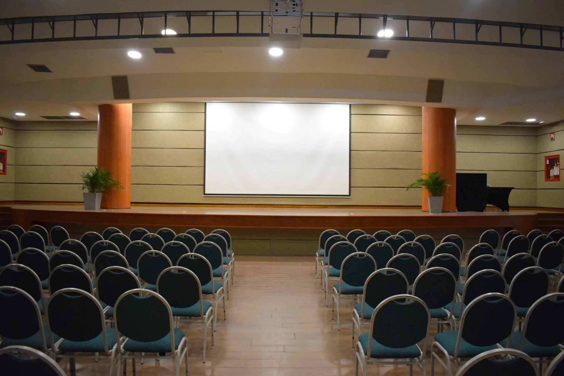 a room with rows of chairs and a projector screen