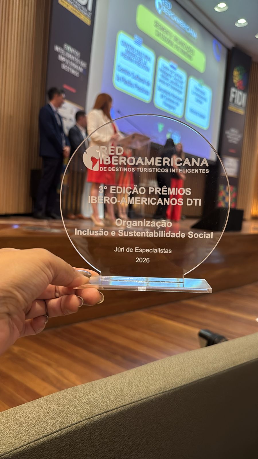 a person holding a glass award