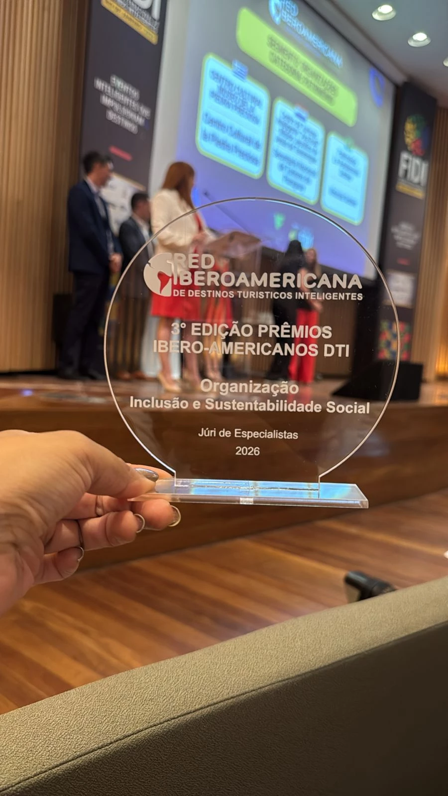 a person holding a glass award