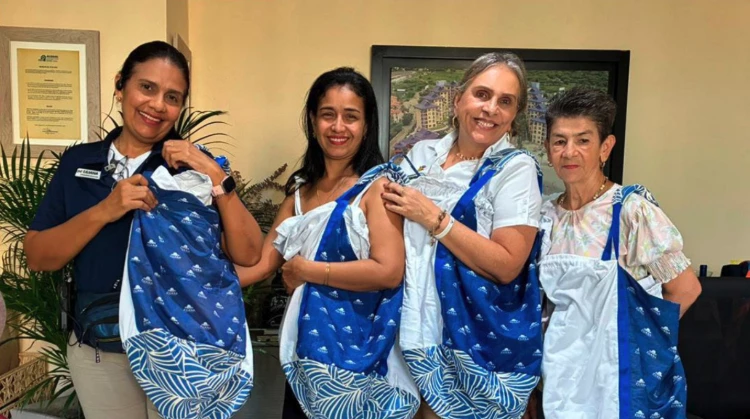 a group of women holding up blue and white bags