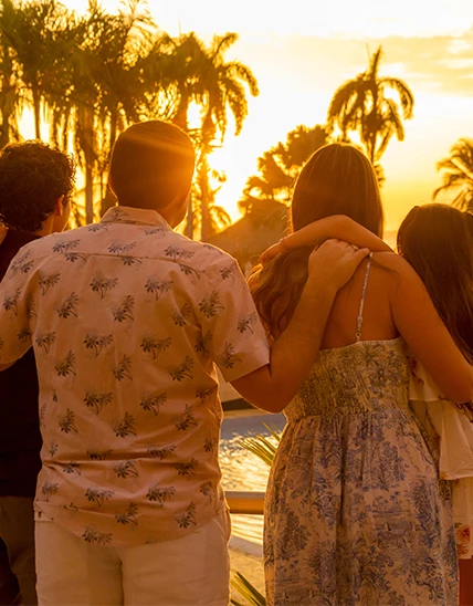 a group of people hugging and looking at the sunset