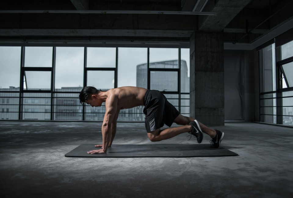 a man doing push ups in a room with windows