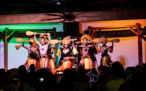 a group of people in clothing holding paddles