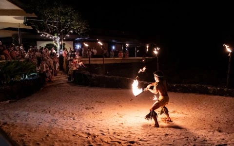a man dancing with fire in the sand