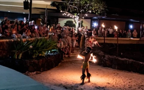 a man dancing with fire in front of a crowd