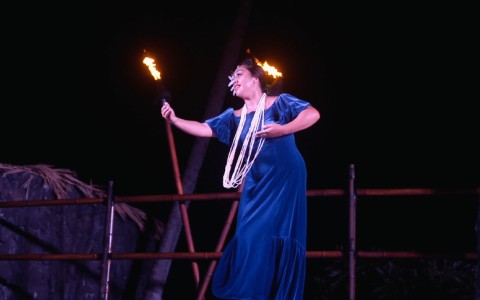 a woman in a blue dress on stage at Royal Kona Resort Luau