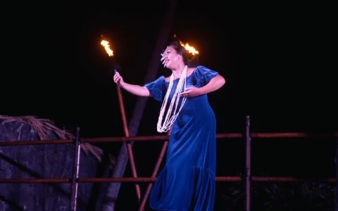 a woman in a blue dress on stage at Royal Kona Resort Luau