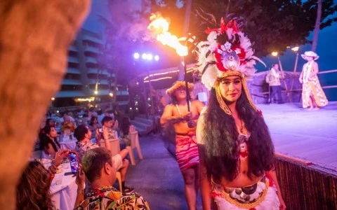 Luau performers entering the stage in front of a live audience