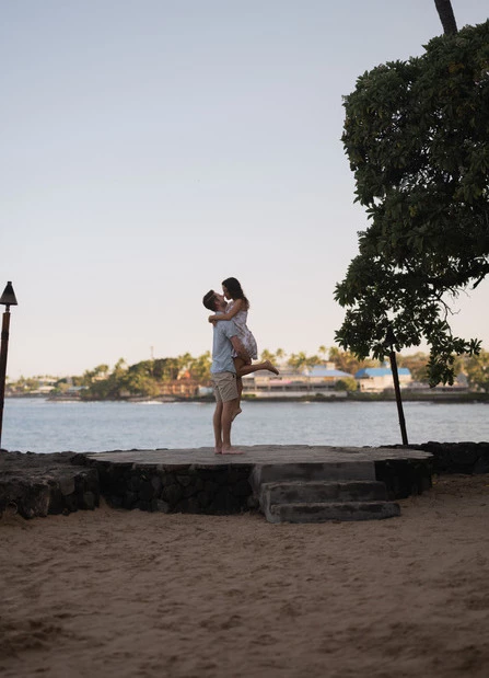 a man holding a woman on a beach
