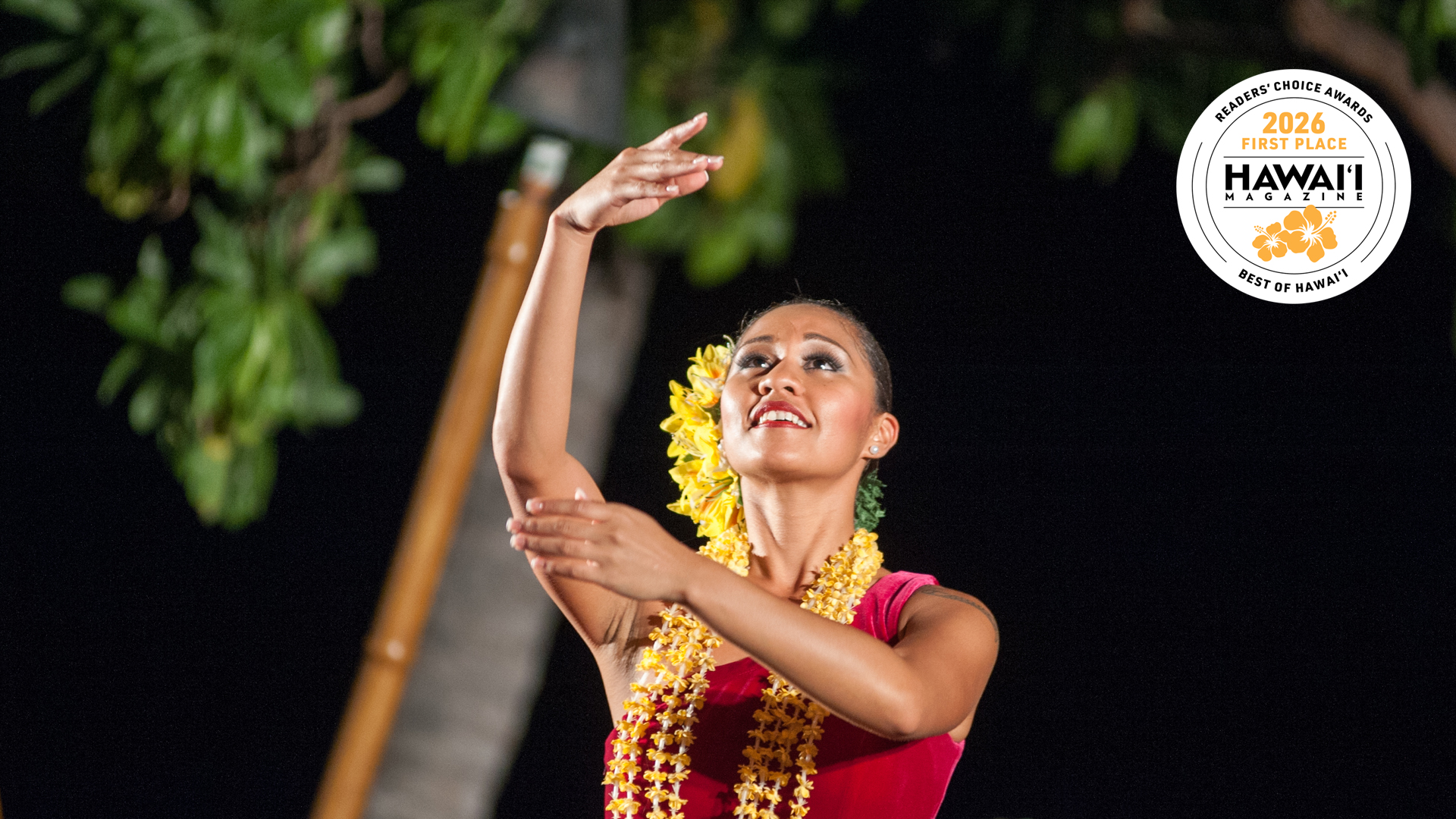 a woman in a red dress dancing at Voyagers of the Pacific Luau at Royal Kona Resort
