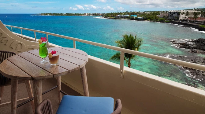 a table and chairs on a balcony overlooking a body of water