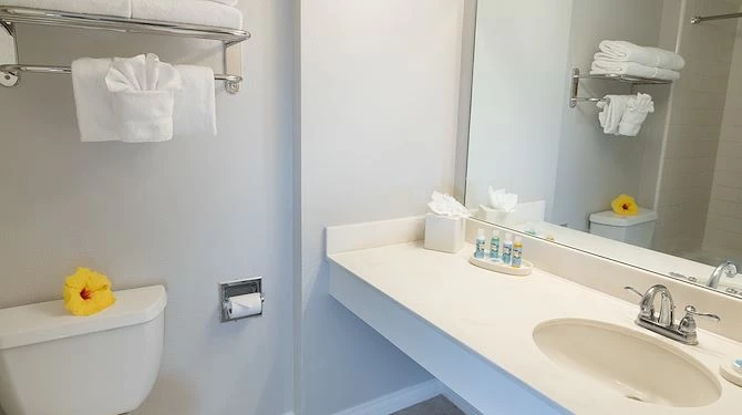 bathroom sink with towels and nearby toilet