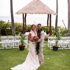 posing with wedding dress and suit and hawaiian leis