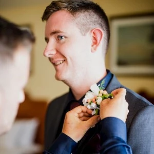 zoomed image of groom getting dressed