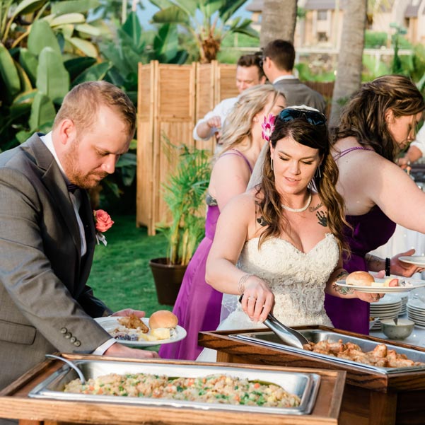 bride and groom serving themselves from the buffet service