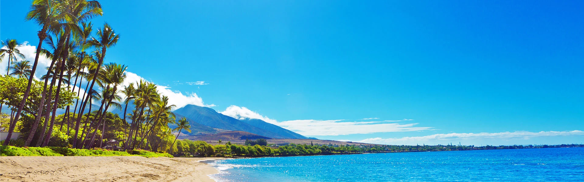 view of a blue sky meeting a blue ocean and a large mountain in the distance