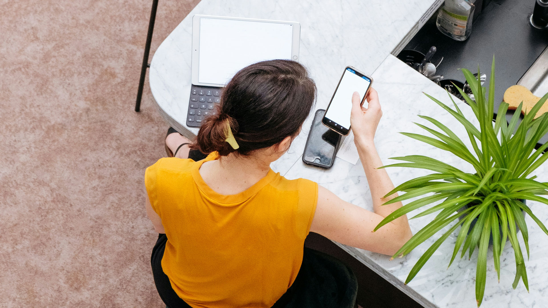 a woman sitting at a table looking at a cell phone