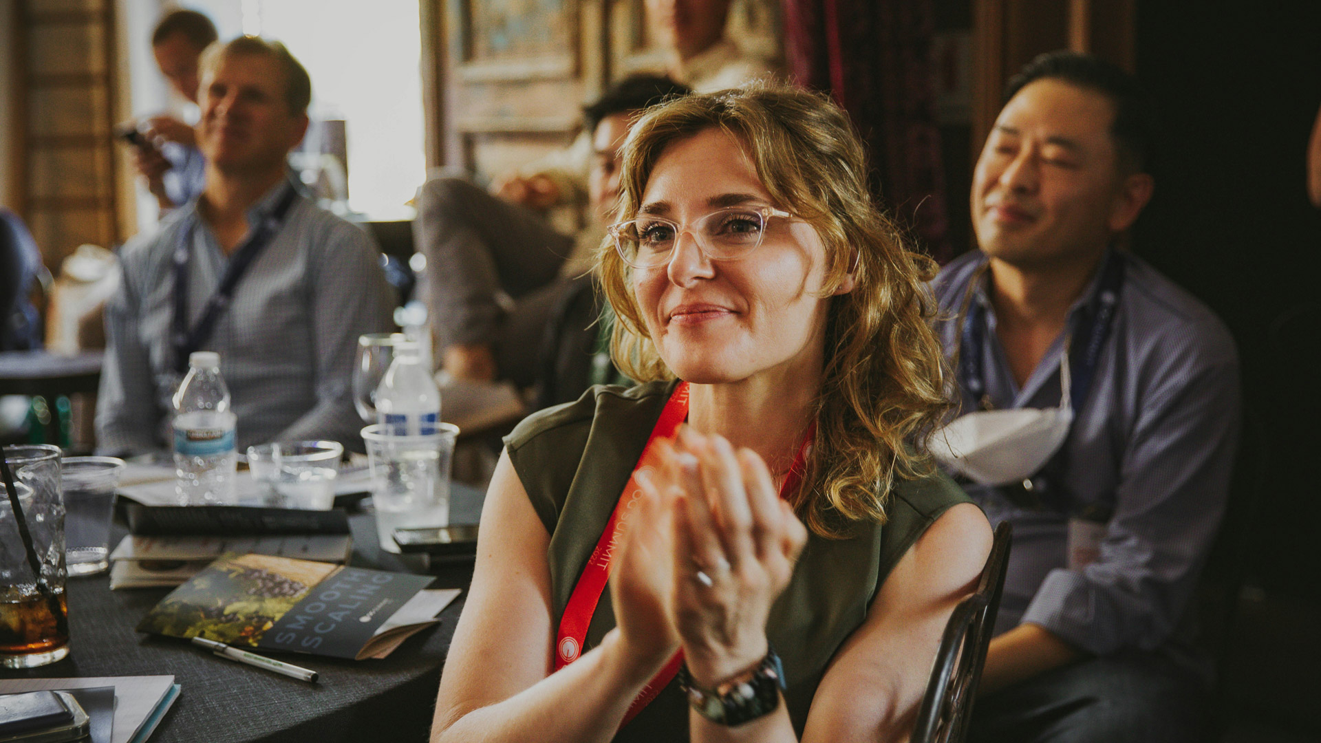a woman sitting at a table with other people