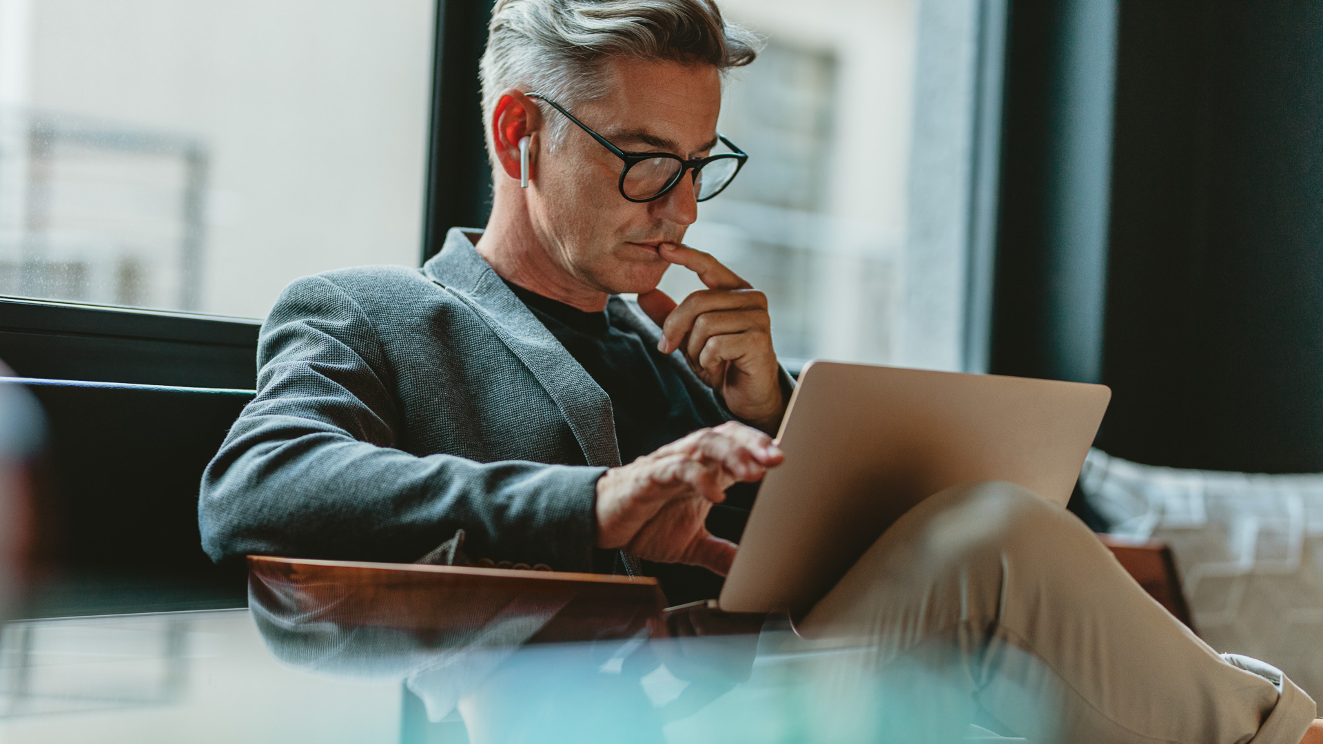 a man wearing glasses and using a laptop