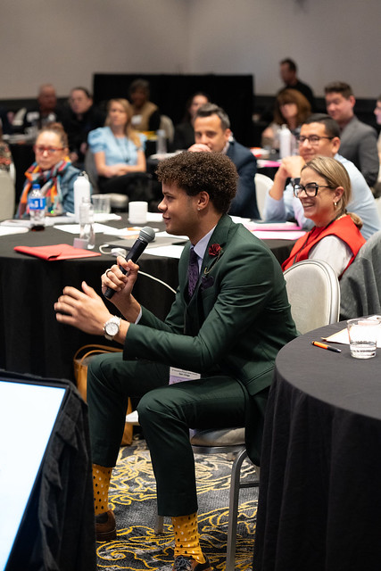 a man in a suit speaking into a microphone