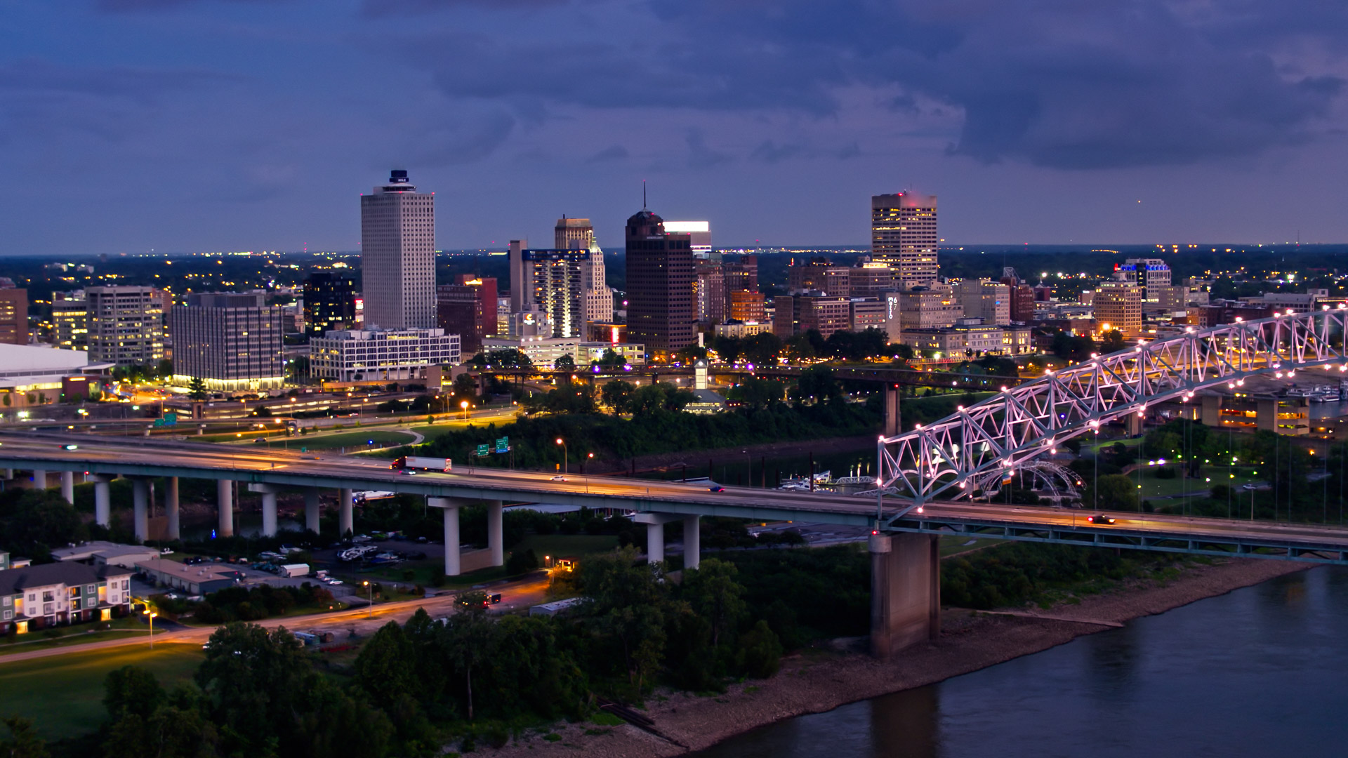 a bridge over a river with a city in the background