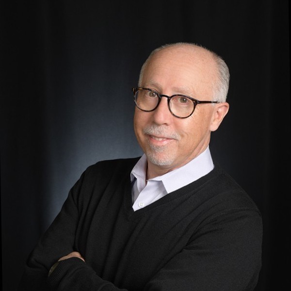 a man wearing glasses and a sweater