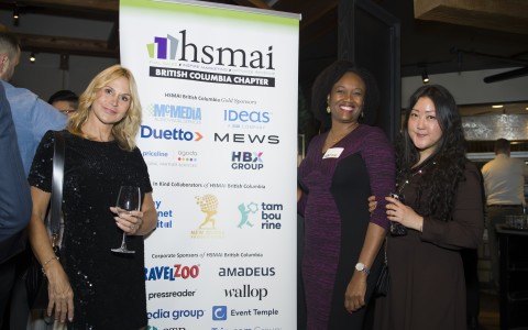 a group of women standing next to a sign
