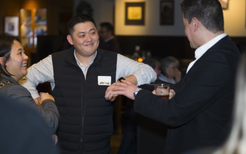 a man in a vest talking to a group of men