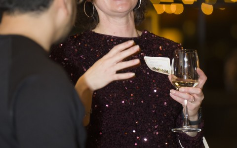 a woman in a sequined dress holding a wine glass