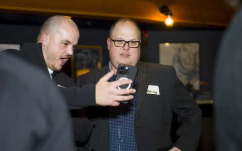 a man taking a selfie with another man