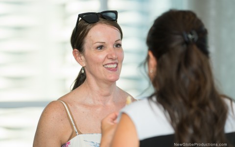 a woman smiling with sunglasses on her head