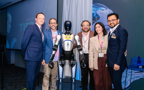 a group of people standing next to a robot