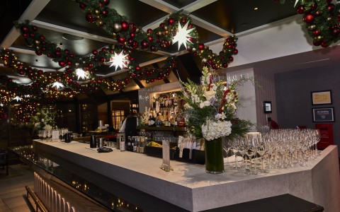 a bar with christmas decorations and glasses
