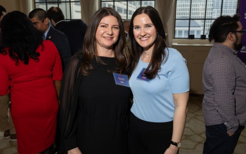 two women standing together smiling