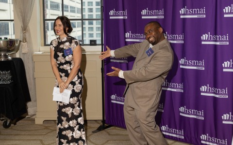 a man and woman standing in front of purple curtains
