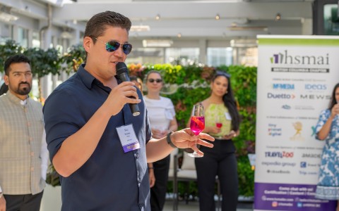 a man holding a microphone and holding a drink