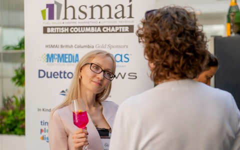 a woman holding a glass of pink liquid